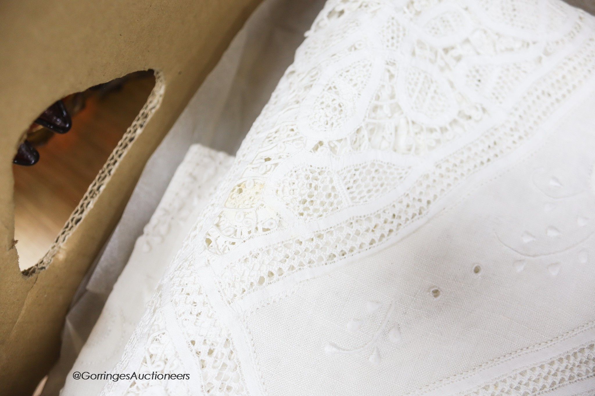 A finely worded tapelace and cutwork white tablecloth with matching serviettes and a similar ecru table cover